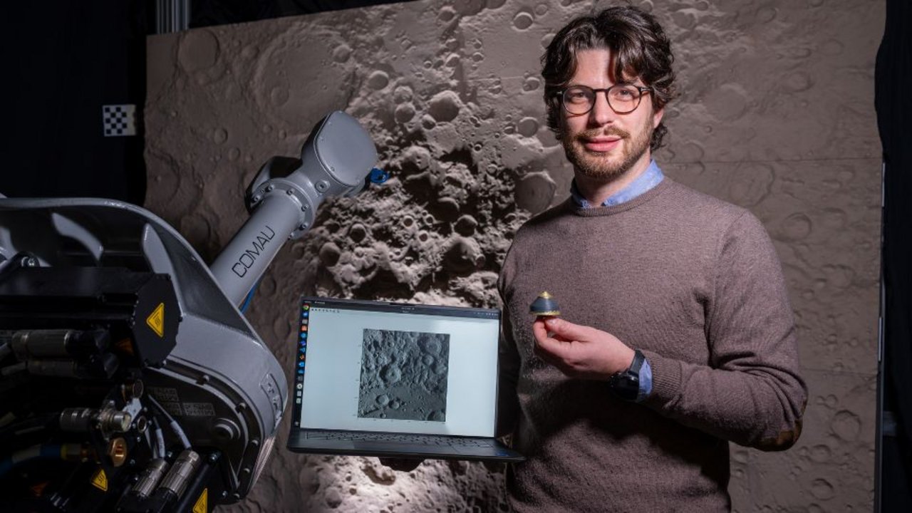 Stefano Silvestrini in ASTRA laboratory with Moon diorama in background and small version of 3D printed orbital debris mockup