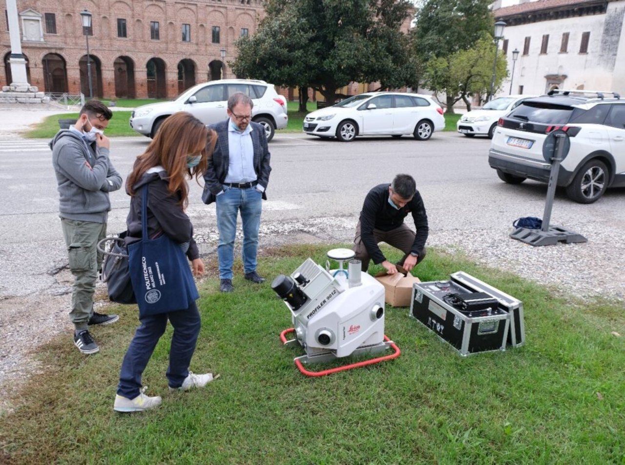 Un gruppo di persone che utilizzano attrezzature topografiche all'aperto