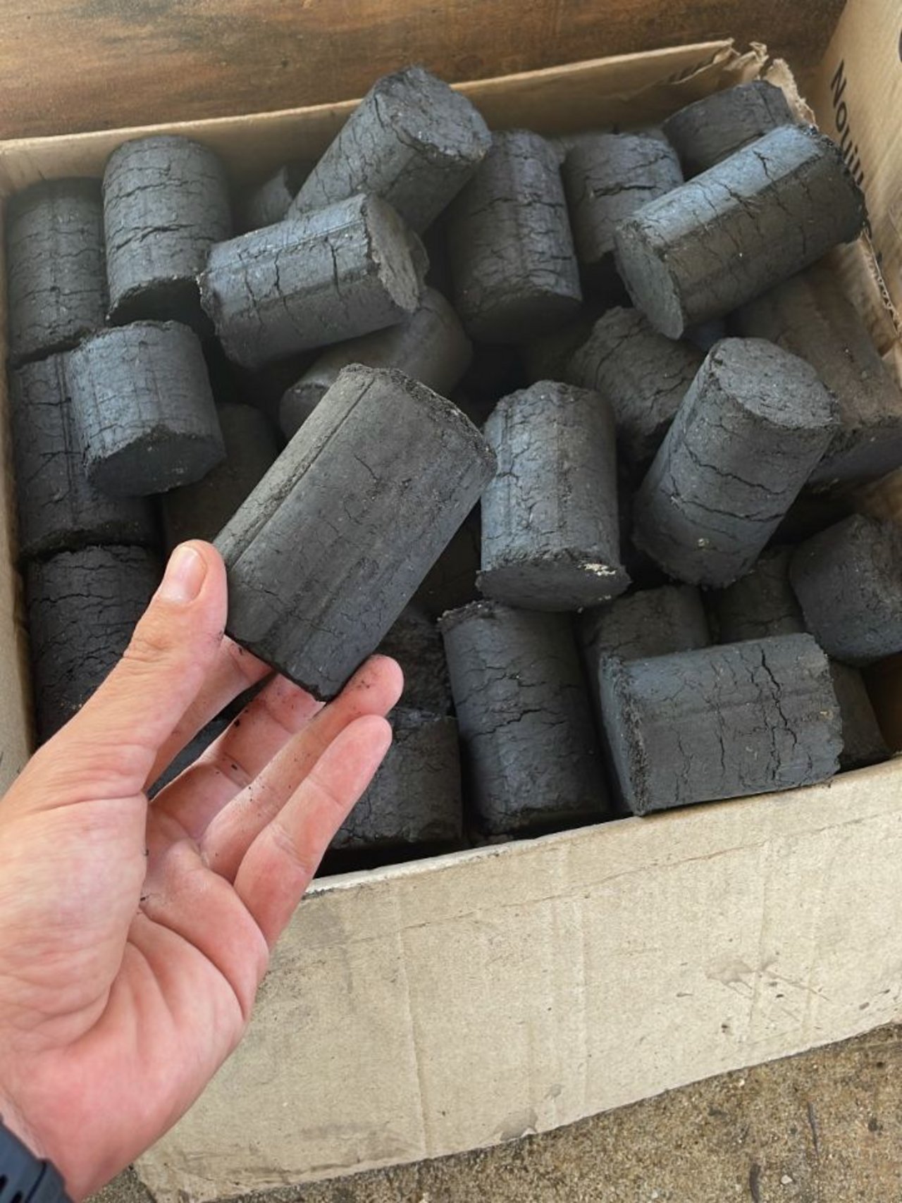 The first box of briquettes produced by CHAR:ME, ready for distribution and use
